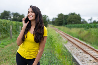 Young woman standing on railroad track