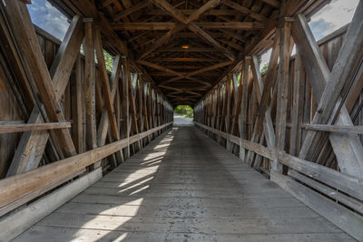 Low angle view of empty covered bridge ahead of you