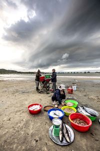 People at beach against sky