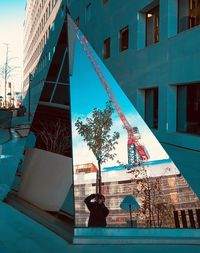 Man in city against sky
