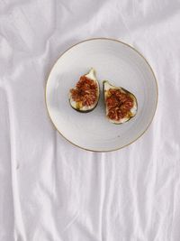 High angle view of figs on the plate on the bed. 