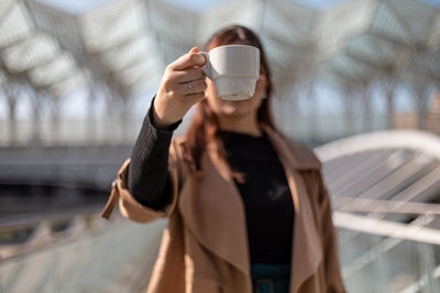 Midsection of woman drinking coffee