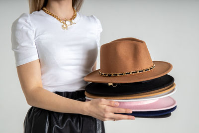 Rear view of woman wearing hat standing against wall