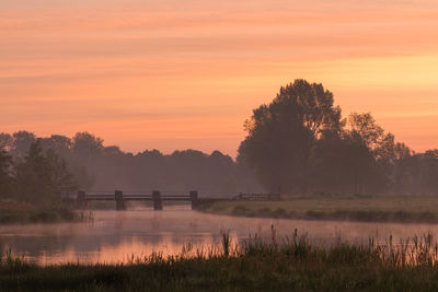 Scenic view of lake against orange sky