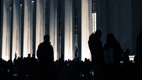 Silhouette people standing against building