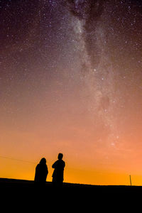 Silhouette people standing against sky at night