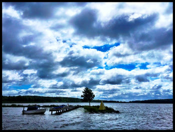 Scenic view of river against cloudy sky