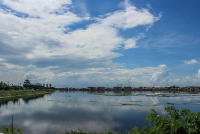 Scenic view of river by trees against sky
