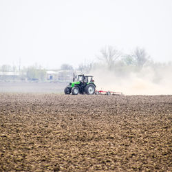 Tractor on field against clear sky