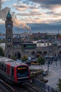 Train against buildings in city during sunset