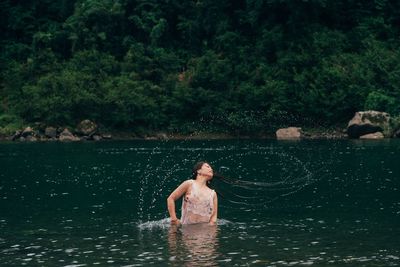 Woman tossing hair in lake 