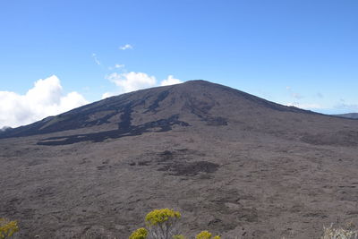 Scenic view of volcanic mountain against blue sky