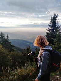 Rear view of woman looking at mountains against sky