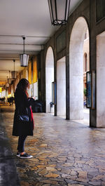 Rear view of woman walking in corridor of building