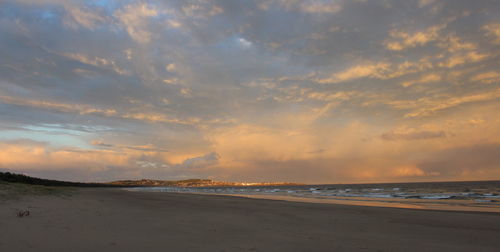 View of beach against cloudy sky