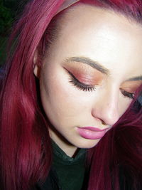 Close-up of beautiful young woman wearing make-up with dyed hair