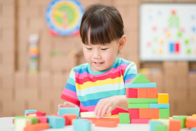 Young girl playing creative toy blocks for homeschooling