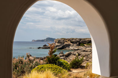 View out of an archway at the rocky coastline at kallithea therms, kallithea spring on rhodes island