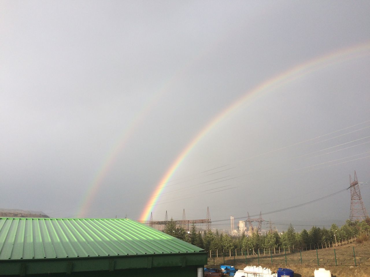 rainbow, multi colored, beauty in nature, built structure, scenics, nature, sky, natural phenomenon, colorful, day, rural scene, majestic, tranquility, no people, cloud - sky, curve, tranquil scene, mountain range, atmospheric mood, the natural world