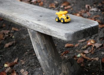 Close-up of yellow toy car on bench