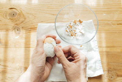 Cropped hand of woman holding food on table