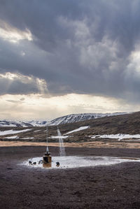 Outdoor hot shower station from geothermal power at krafla against cloudscape