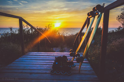 Close-up of skateboard on footbridge against sky