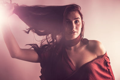 Portrait of beautiful young woman against white background