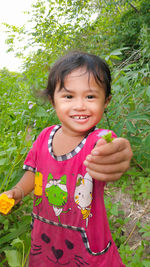 Portrait of smiling girl holding plant