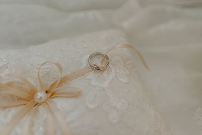 Close-up of wedding rings on white flower