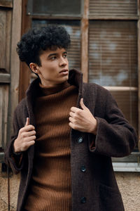 Portrait of young woman holding book at home