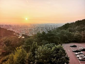 High angle view of trees and buildings against sky during sunset