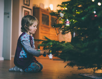 Girl in christmas tree at home