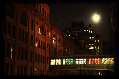 Low angle view of buildings against sky at night