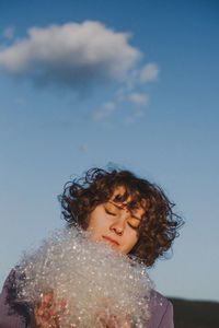 Woman with at plastic against blue sky