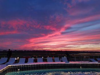 Scenic view of swimming pool against sky at sunset