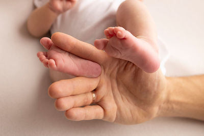 Cropped image of baby on bed