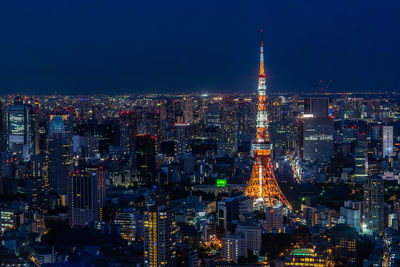 Aerial view of illuminated tower in city at night