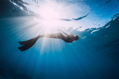 Low section of man swimming in sea