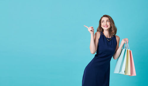 Woman standing against blue background