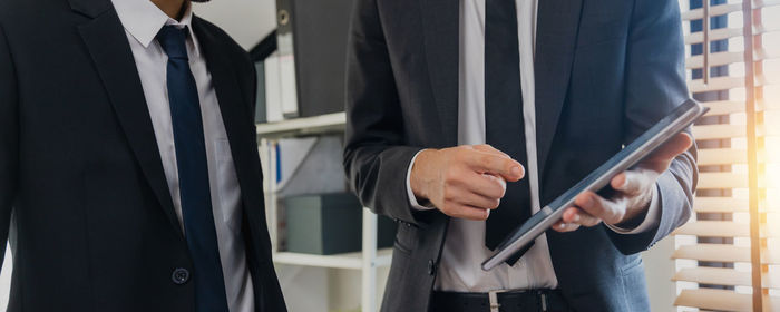 Midsection of businessman using mobile phone