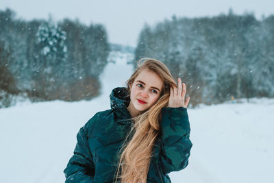 Young woman standing on snow covered field