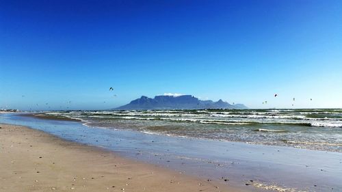 Scenic view of beach against blue sky