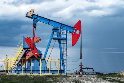 Low angle view of crane against sky