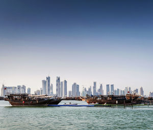 Sea and buildings against clear sky