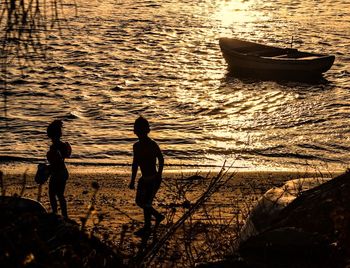 People in boat at sunset