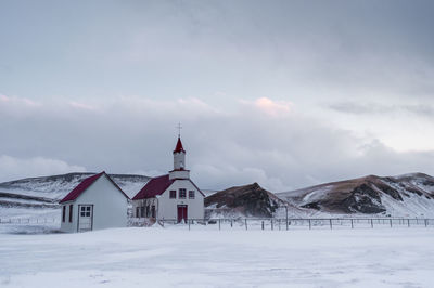 Houses on snowcapped mountain against sky