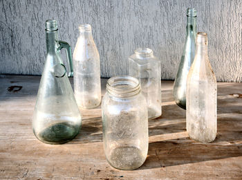 Glass bottles on the wooden table at dawn