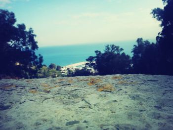 Close-up of rocks by sea against sky