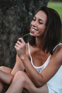 Midsection of a smiling young woman holding ice cream